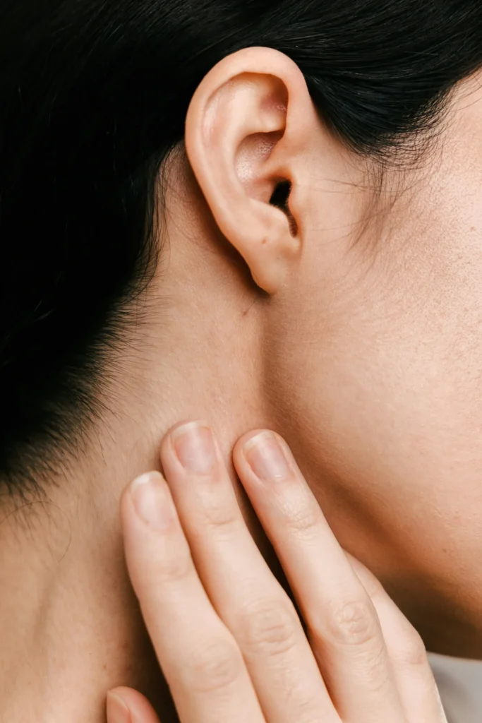 Woman with hand next to ear during auricular acupuncture session